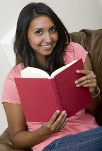 A beautiful woman reading a book on the couch